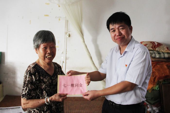 1530177353914210.jpg 岑廷義將慰問金交到莫秋嬌手中.jpg